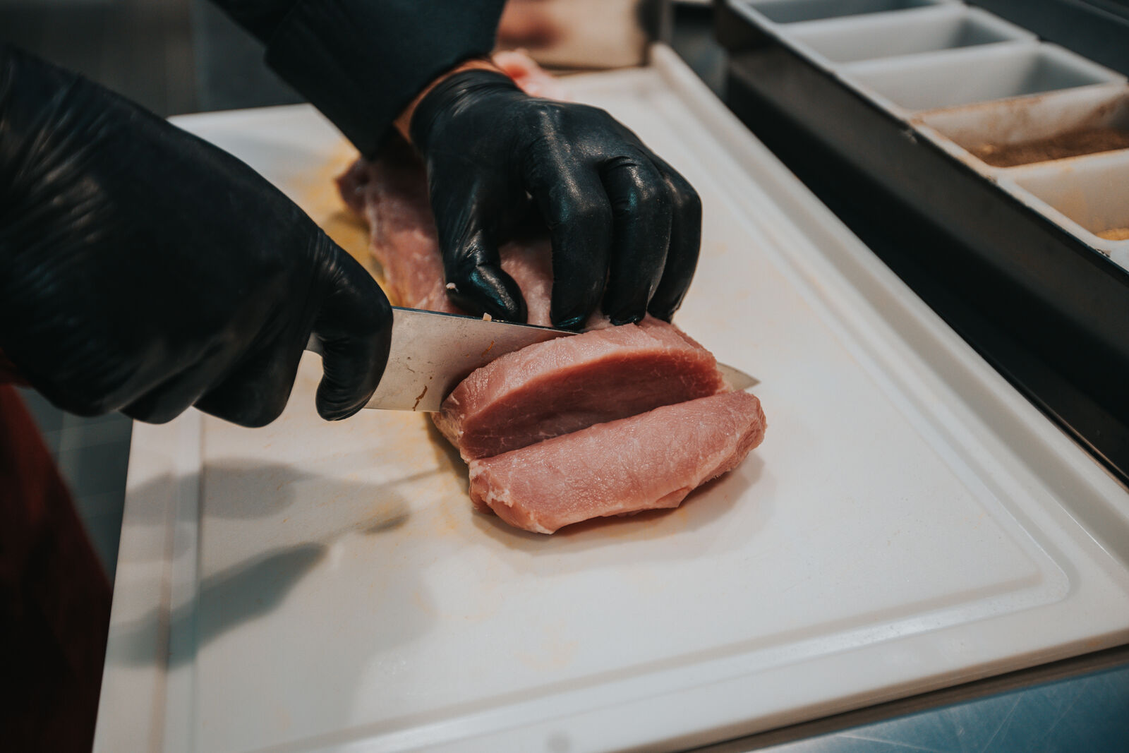 In der Küche wird Fleisch aufgeschnitten