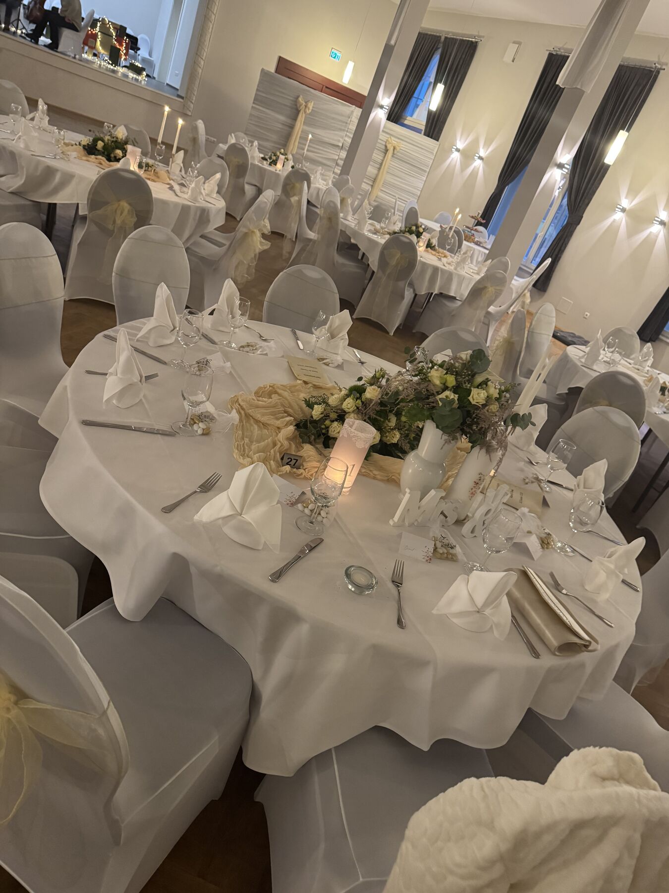 Hochzeitstafel im Saal mit Blumen und Kerzen