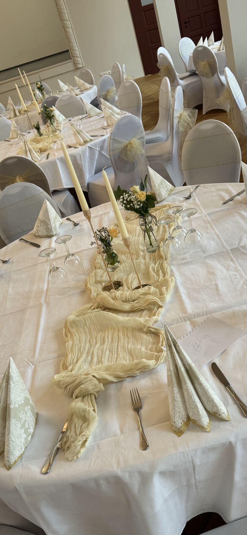 Tisch im Saal mit Kerzen und heller Dekoration