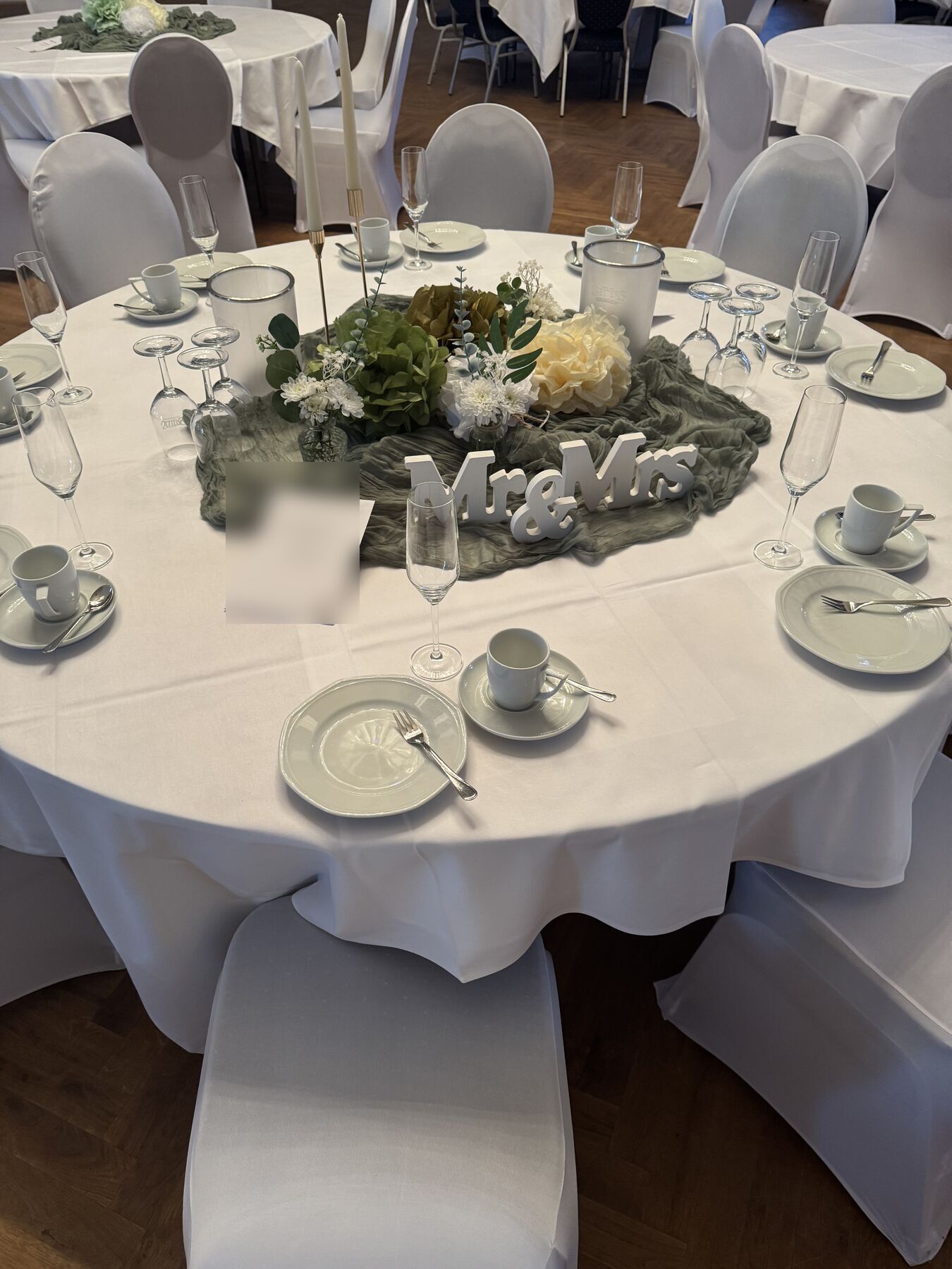 Runder Tisch im Saal, gedeckt für ein Brautpaar