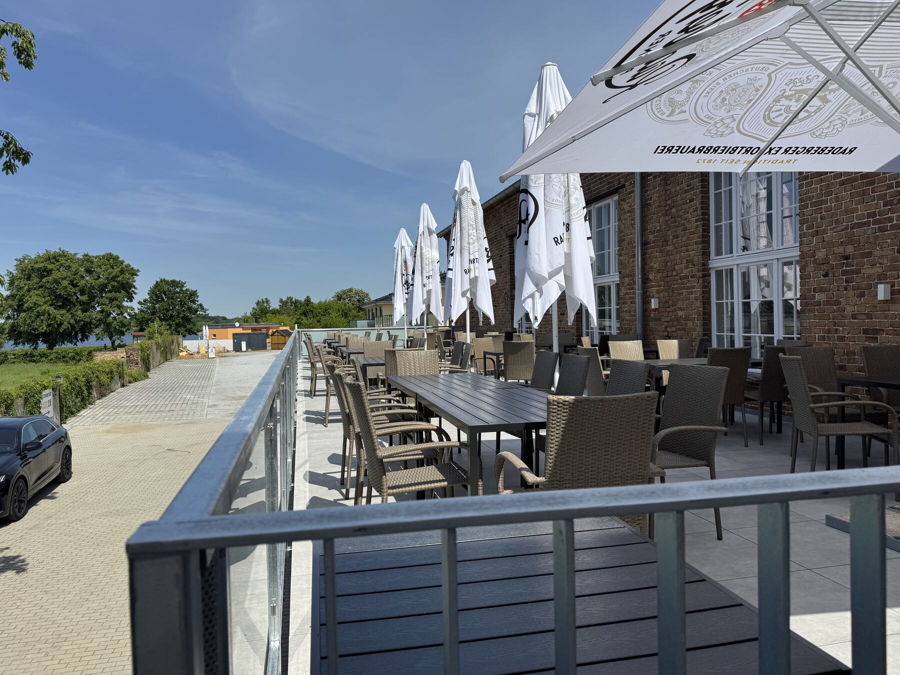 Terrasse des Dorfkrugs mit Sonnenschirmen